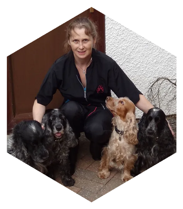 Karen crouching outside her salon with four Cocker Spaniels